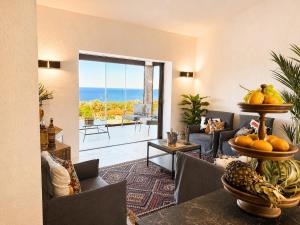 a living room with a couch and a table with fruit at Villa Ottavio Costa Smeralda View 360 in San Pantaleo