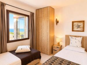 a bedroom with two beds and a window at Villa Ottavio Costa Smeralda View 360 in San Pantaleo +18 photos