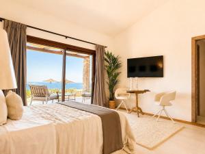 a bedroom with a bed and a large window at Villa Ottavio Costa Smeralda View 360 in San Pantaleo