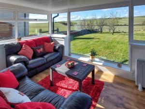a living room with a couch and a table at Wee Dug Hoose in Glenluce
