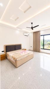 a bedroom with a bed and a ceiling fan at Mountain top farmhouse in Gurgaon