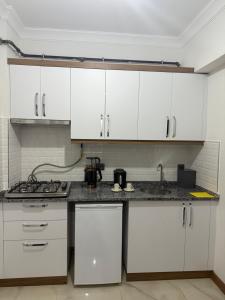 a kitchen with white cabinets and a counter top at suite palace in Kapullu