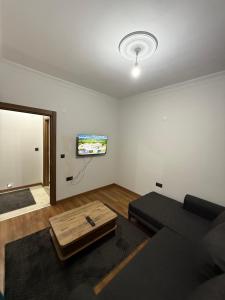 a living room with a couch and a flat screen tv at suite palace in Kapullu