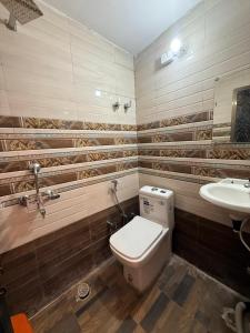 a bathroom with a toilet and a sink at Guru Amrit Residency & Guru Kripa Guest house in Ayodhya