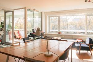 a living room with a table and chairs and windows at Spacious cocoon with a terrace view on the canal in Paris