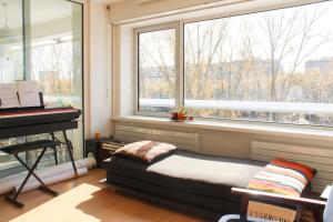 a bedroom with a bed next to a window with a piano at Spacious cocoon with a terrace view on the canal in Paris