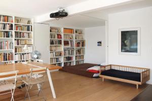 a room with a bed and a desk and book shelves at Spacious cocoon with a terrace view on the canal in Paris