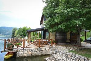 a house with a boat in the water next to a building at Vikendica Family in Gojsalica