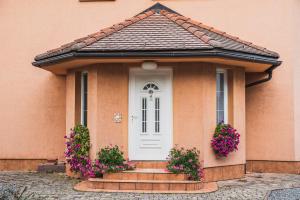 a small house with a white door and flowers at Hide Away in a Private Countryside Villa in Prestranek
