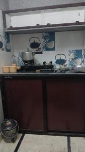 a kitchen with pots and pans on a stove at Krishna's land Homestay in Vrindāvan +10 photos