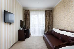 a hotel room with a couch and a television at Kasimir Hotel & SPA in Bukovel