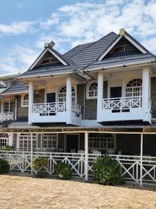 a large house with a white fence in front of it at Balmoral Palace Kisumu in Kisumu International Airport