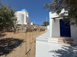 a building with a blue door and stairs next to a building at Nion Stays in Katapola