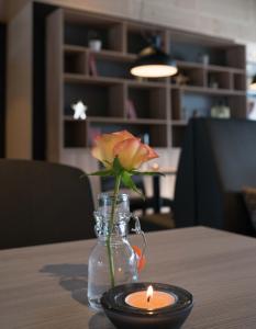 eine Kerze und eine Blume in einer Vase auf einem Tisch in der Unterkunft Thon Partner Hotel Vinstra in Vinstra