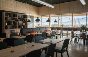 ein Restaurant mit Tischen und Stühlen und großen Fenstern in der Unterkunft Thon Partner Hotel Vinstra in Vinstra