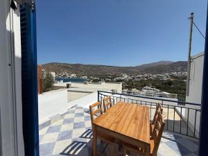 a wooden table on the balcony of a house at Nion Stays in Katapola