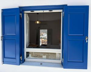 a blue door with a mirror in a room at Nion Stays in Katapola