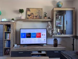 a television sitting on a wooden table in a living room at Guetsel-Lodge - Δ in Gütersloh