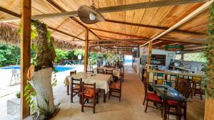a restaurant with a table and chairs under a wooden ceiling at Entre Bosques Tayrona in Los Naranjos