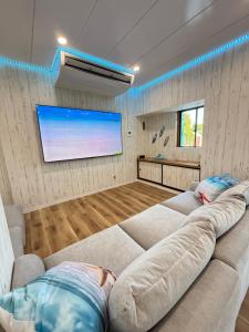 a living room with a large couch and a flat screen tv at Yumigahama Eaglehouse 2 in Minamiizu