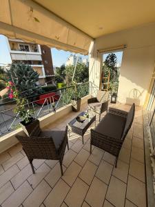 a patio with chairs and a table on a balcony at Velinora House in Rafina