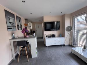 a living room with a desk and a flat screen tv at Guetsel-Lodge - Δ in Gütersloh