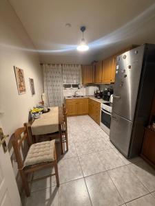 a kitchen with a table and a stainless steel refrigerator at Velinora House in Rafina