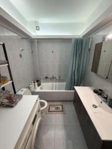 a bathroom with a tub and a toilet and a sink at Velinora House in Rafina +7 photos