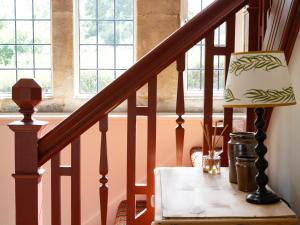 a lamp on a table next to a staircase at Costers Lodge in Midhurst