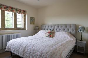 a bedroom with a large bed and two windows at Costers Lodge in Midhurst