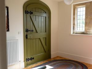 a green door in a room with a rug at Costers Lodge in Midhurst
