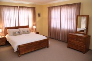 a bedroom with a bed and a mirror and a dresser at Monotoka Self Catering Apartments CC in Swakopmund