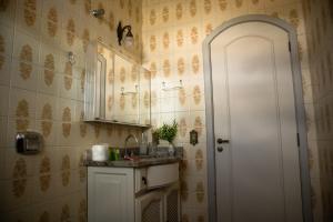 a bathroom with a sink and a mirror at Dom Ravello in Telêmaco Borba
