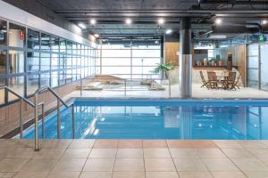 a swimming pool in an office building with a pool at Scandic Rosendahl in Tampere