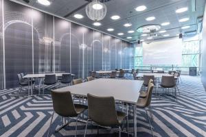 a conference room with tables and chairs and a projection screen at Scandic Rosendahl in Tampere +45 photos