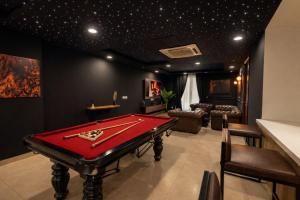 a billiard room with a red pool table in it at Gold Crest Signature Boutique Apartments With City Views -DHA PHASE 4 LAHORE in Lahore