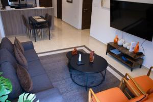 a living room with a blue couch and a table at Sky View Condo at Solaris in Christiansborg +3 photos