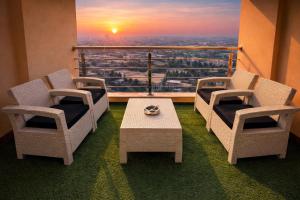 a balcony with two chairs and a table with a view at Gold Crest Signature Boutique Apartments With City Views -DHA PHASE 4 LAHORE in Lahore