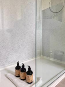 three bottles sitting on a shelf in a bath tub at Auch - Trail Cabins in Bridge of Orchy