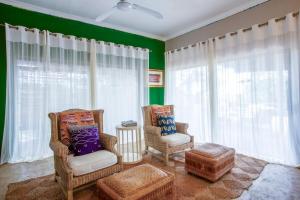 a living room with two chairs and a couch at Baleia Azul 24 in Ponta Mamoli