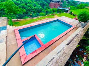 an overhead view of a large swimming pool at Mountain top farmhouse in Gurgaon