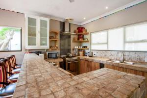 a kitchen with a large counter top in a room at Baleia Azul 24 in Ponta Mamoli +28 photos