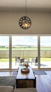 a living room with a table and chairs and a chandelier at Birch Tree Lodge - Luxurious Lodge on the NC500 by Thrumster Lodges in Wick