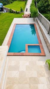 an empty swimming pool in a yard with a lawn at Mountain top farmhouse in Gurgaon +19 photos