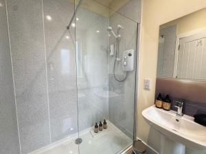 a bathroom with a shower and a sink at Auch - Trail Cabins in Bridge of Orchy