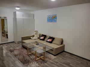 a living room with a couch and a glass table at Private bedroom in Shared Apartment in Hämeenlinna