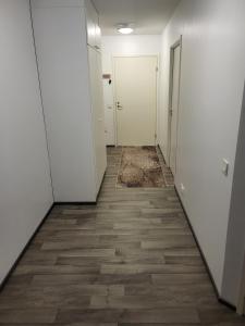 an empty hallway with white walls and wooden floors at Private bedroom in Shared Apartment in Hämeenlinna