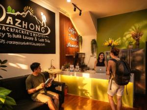a man sitting on a couch in a waiting room at Medan Dazhong Backpacker's Hostel in Medan +21 photos