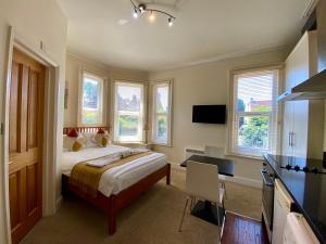 a bedroom with a bed and a desk and windows at Noa Residence in Oxford