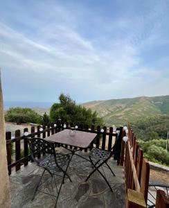 a table on a balcony with a view of the mountains at Domaine Santa Petronilla "chapelle" in Rogliano
